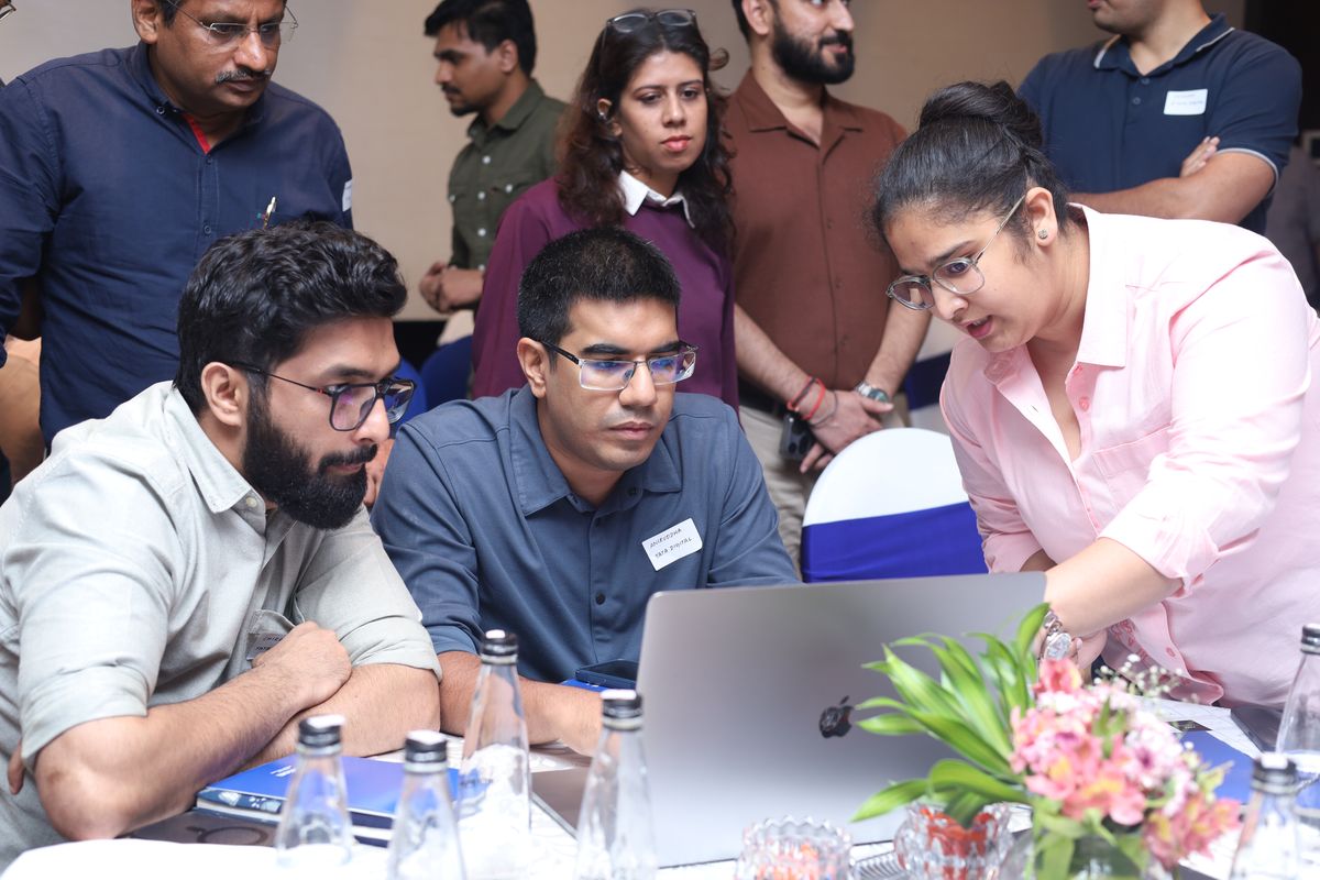 Attendees gathered round a laptop, working through an exercise together