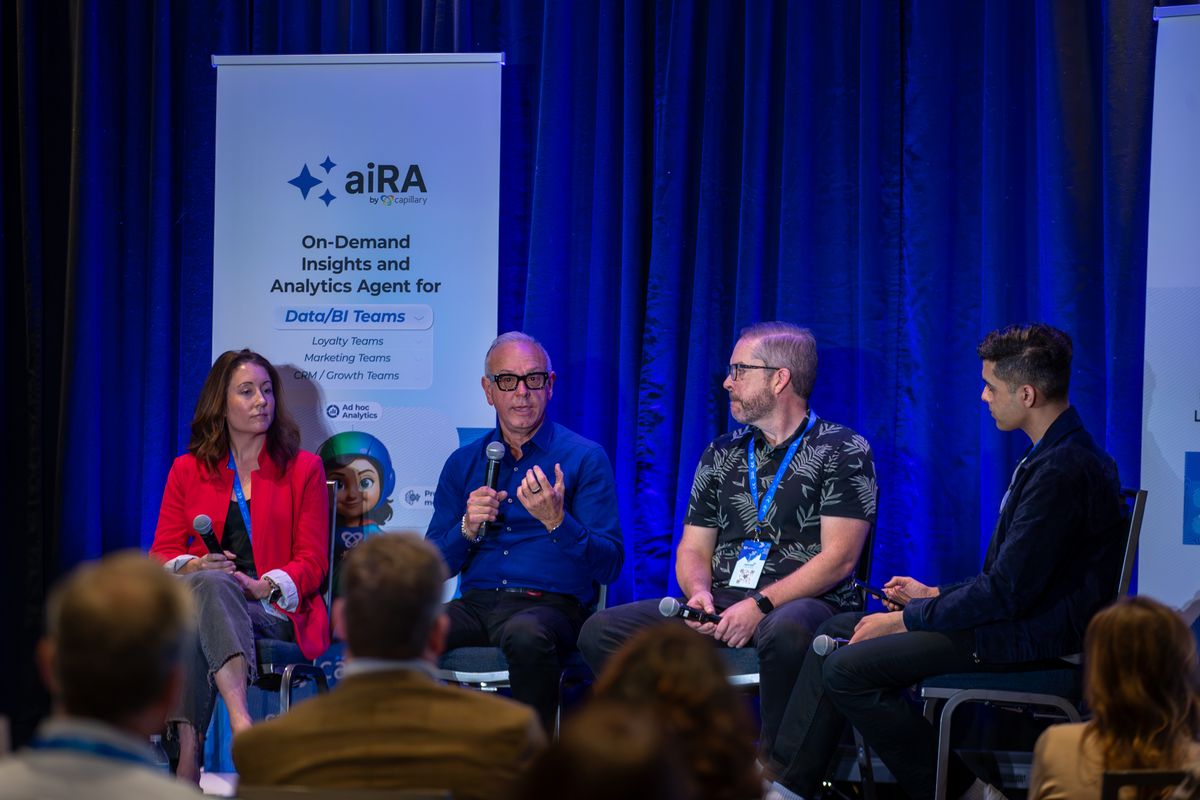 A panel discussion on stage beside an aiRA banner